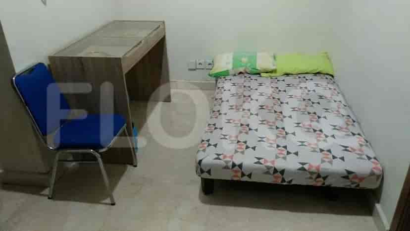 A small bedroom with a single bed and a desk.