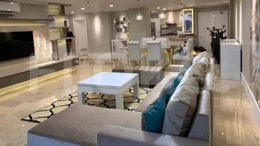 A dining area with a glass-top table and white chairs.