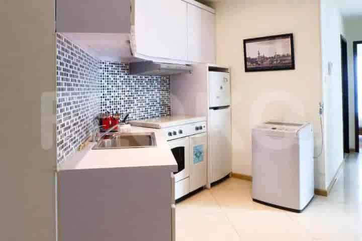 A small kitchen featuring white cabinets, a stove, and a refrigerator.
