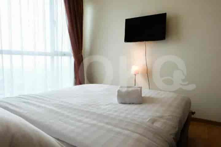 Bedroom featuring a bed with white bedding and a wall-mounted TV.