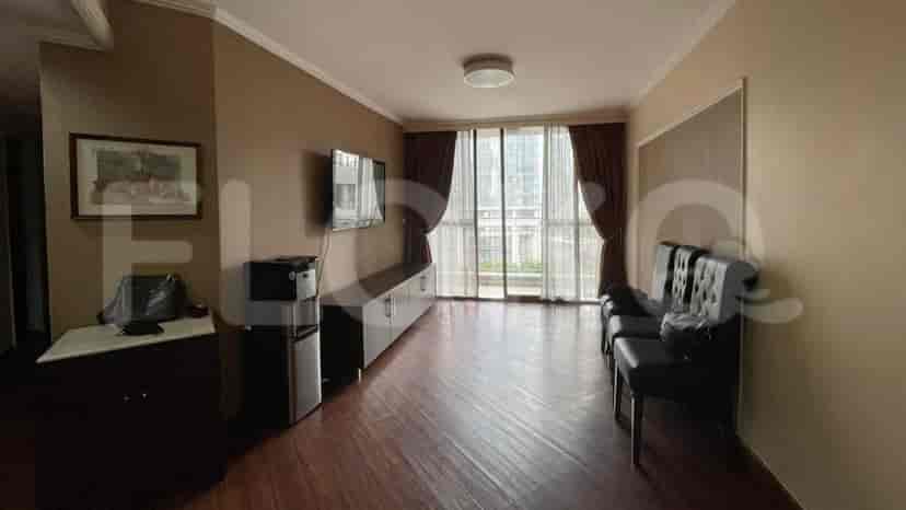 A living room with a wall-mounted TV, water dispenser, and a view through the window.