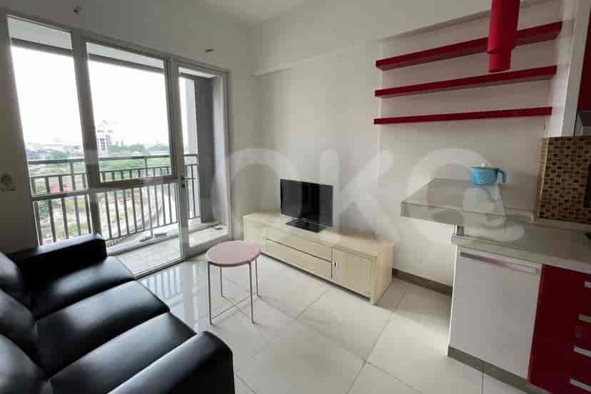 Modern living room with balcony, TV, sofa, and small coffee table.