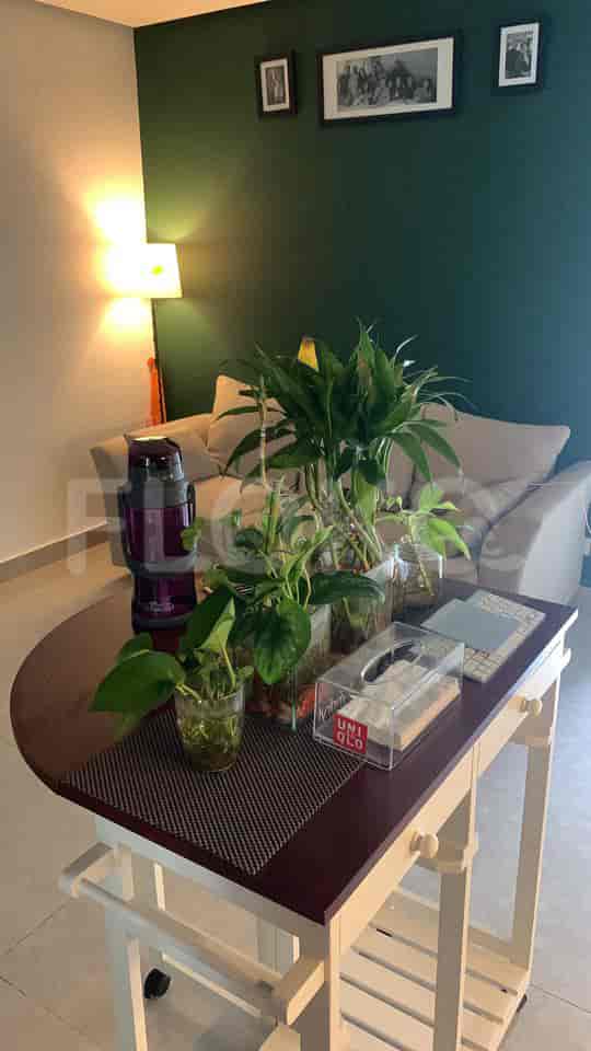 Living room with a round table and plants.