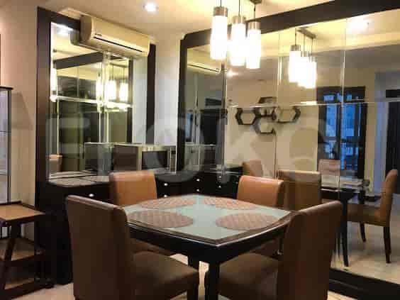 Elegant dining area with a square table, mirrored walls and modern lighting.