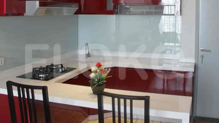 Close-up of the kitchen with red cabinets, gas stove, and a white countertop.