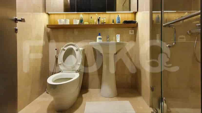 A small bathroom with a sink, toilet, and shower area.
