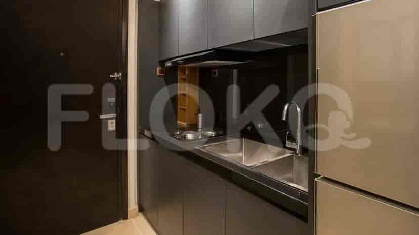 A compact, modern kitchen featuring a stove, sink, and cabinets.
