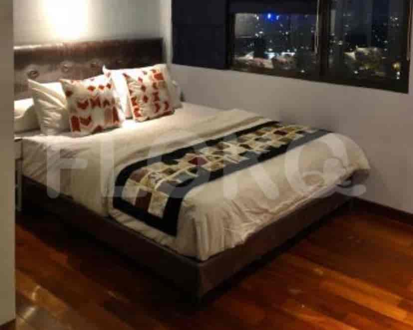 A bedroom with a bed, pillows, and a window with a view.