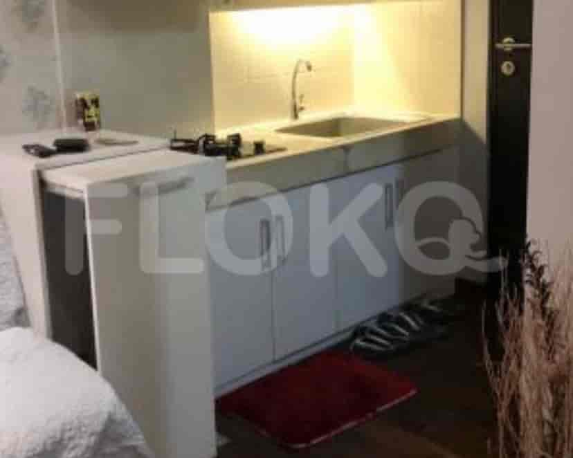 A compact kitchen with white cabinets, a sink, and a small stovetop.