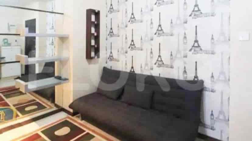A living room with a sofa, desk and Eiffel Tower wallpaper.