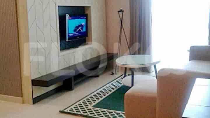 A living room with a TV, sofa, and rug.