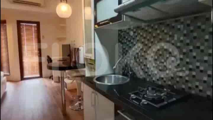 A compact kitchen with a stove, sink, and overhead cabinets, providing a functional cooking space.