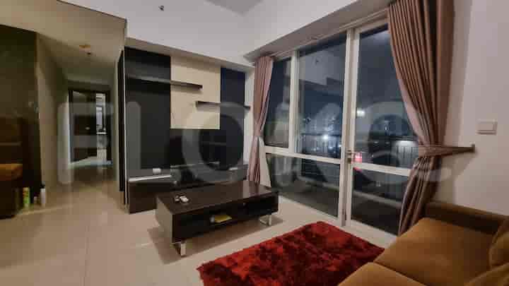 Ruang tamu modern dengan sofa, TV, dan jendela besar.
