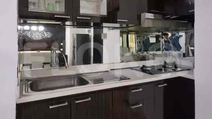 Dapur modern dengan peralatan stainless steel dan meja putih.