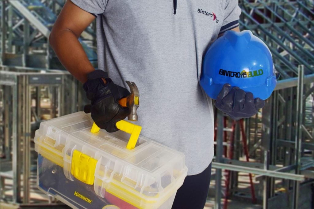 Man from Bintoro Build carrying a tool box and safety helmet