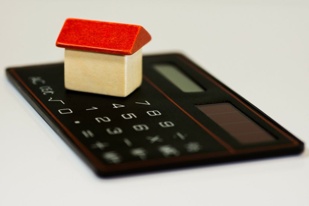 (budgeting) miniature house on top of a calculator