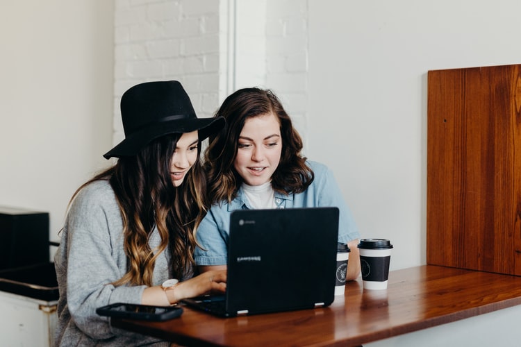 two women work together