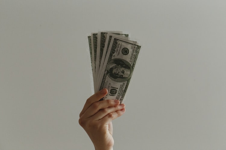 hands holding 100 dollar money