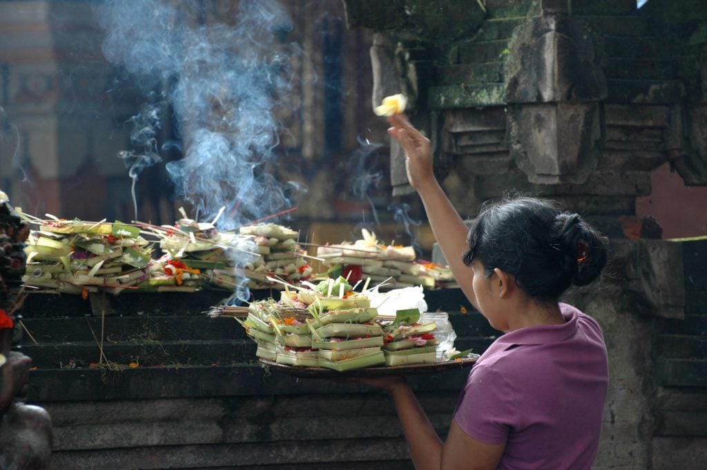 praying during canang sari process