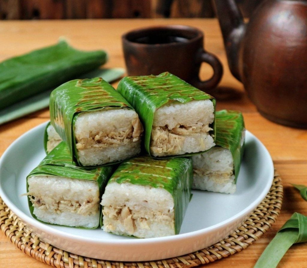 Indonesian snack called lemper serve in banana leaves on the plate